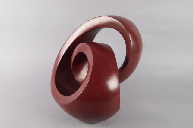 Cast Sculpture: 12" H x 12" W cast sculpture, hydrostone dark red patina, titled "Infinite Mobius," No. 1, 1982, Elias (Louis Stevenson).