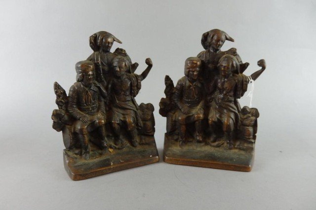 Pair of Cast Iron Bookends: Images of three people 2 seated on rock wall, measures 7.75" x 6"