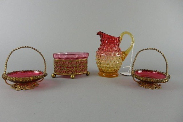 Lot of Four Pieces Victorian Glass: Lot includes two 3" W blown cranberry master salts, set in brass wire baskets; 2.5" T x 3.5" L x 2" W four-footed Victorian cranberry glass bowl set in a wire frame; 5" T hob-nail amberina cream pitch