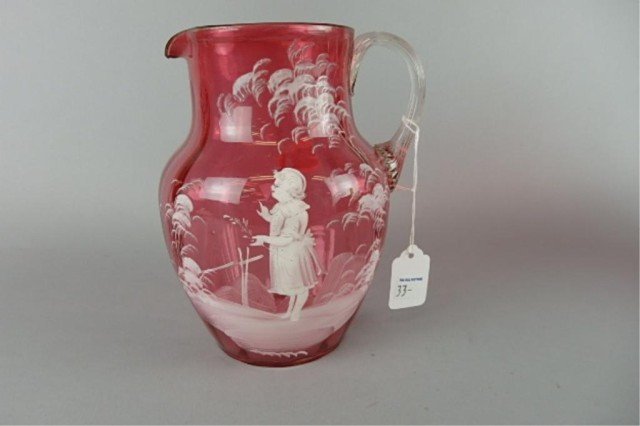 Mary Gregory Cranberry Blown Glass Pitcher: 7.5" T x 5" W with applied clear handle, white enamel decoration depicting a young girl; some slight flaking near base.