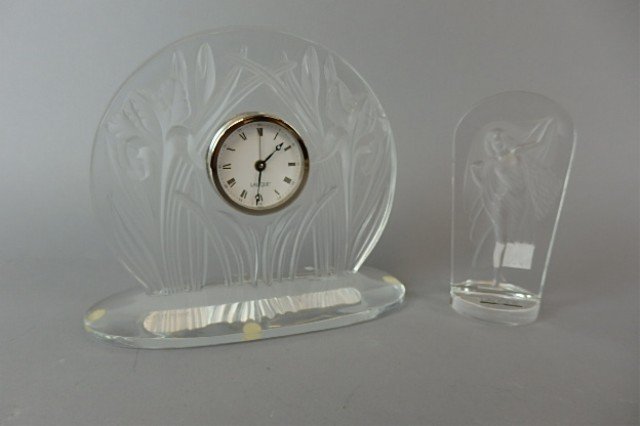 Two Pieces of Lalique: Two pieces of Lalique includes 6.75" x 8" desk clock, frosted Irises on clear base and a 5.5" Lalique Society 1990, image of a woman in a flowing dress, original paper label.