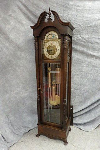 Mahogany Tall Case Clock: 81" tall case clock with Westminster Chime, Colonial Mfg., decorative brass face, hour and second hands, Westminster Chime, moon face, calendar, nine tubes and three weights, beveled glass door, full