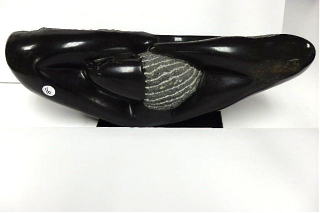 Stone Carving: measures 10.5"T x 26.5"L x 8"D. Person reclining, Weight approx. 100 -200 lbs. Artist: L.Takawira Title: "Ralaxing" Medium: Springstone