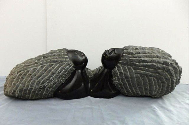 Stone Carving: 2 Faced Woman, masures 10" x 32"L x 8"W, Weight approx. 60-80 lbs, Signed OAK Artist: Lazarus Takawira Title: Talking Secrets Medium: Spring stone