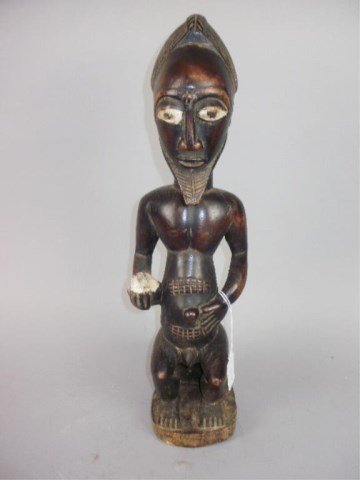 Carved African Figure: 17" tall carved wood nude seated male holding a white object"Dogon" art from different West African countries.