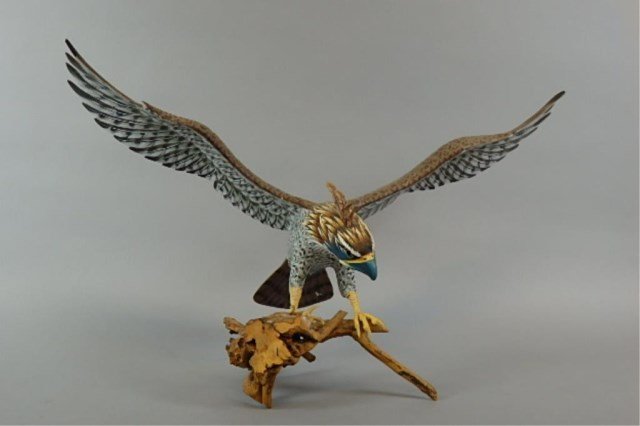 Folk Art Wood Carving: Folk art wood carving of an bird/falcon, 14.5" tall x 23" long x 12" wide, all carved and hand paint-decorated of an eagle with spread wings on a tree branch, three talons repaired.