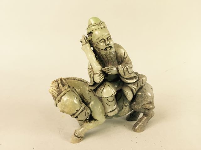 Carved Jade Figure: 6" x 5" figure of an Asian man seated on a horse holding bamboo.