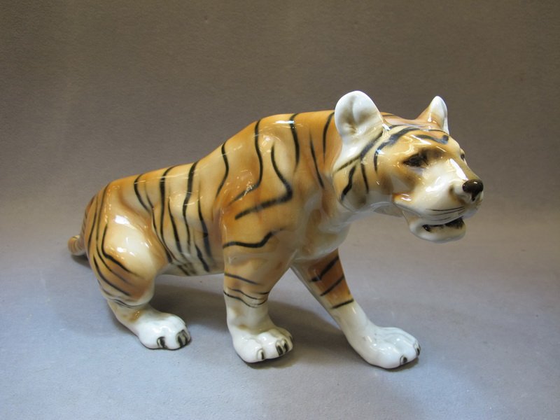 Royal Dux tiger porcelain statue: Royal Dux tiger porcelain statue, marked. 9 1/2" H x 20” W. Shipping in USA is $ 45.00. International bidders ask for shipping before bid.