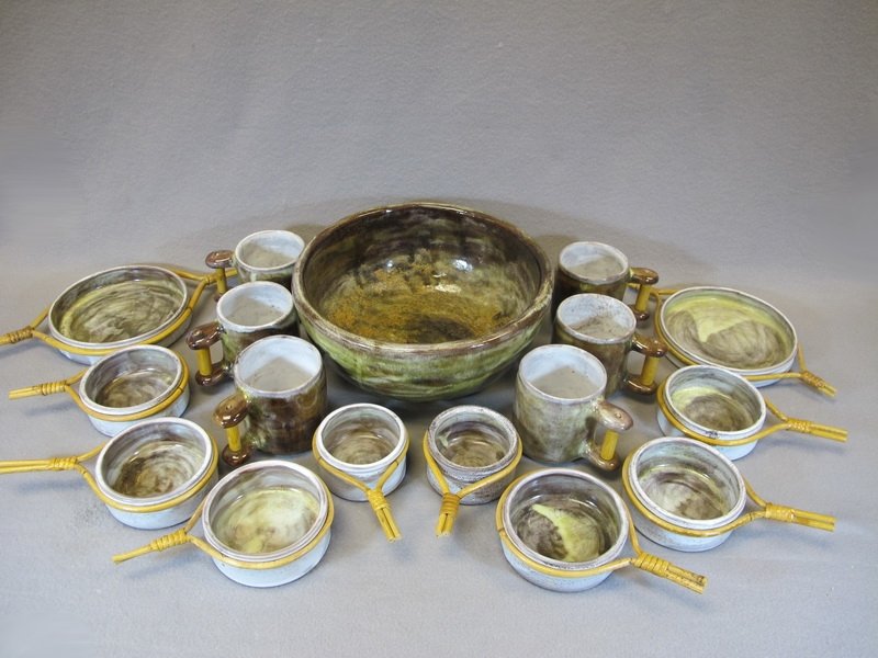 Robert & Jean Cloutier France pottery set: Robert & Jean Cloutier France pottery set with wicker handles, 17 pieces, signed. Bowl: 5 5/8” H x 12 1/8” W. Cup: 4” H x 3 3/4” W without handles. Shipping in USA is $ 75.00. International bi