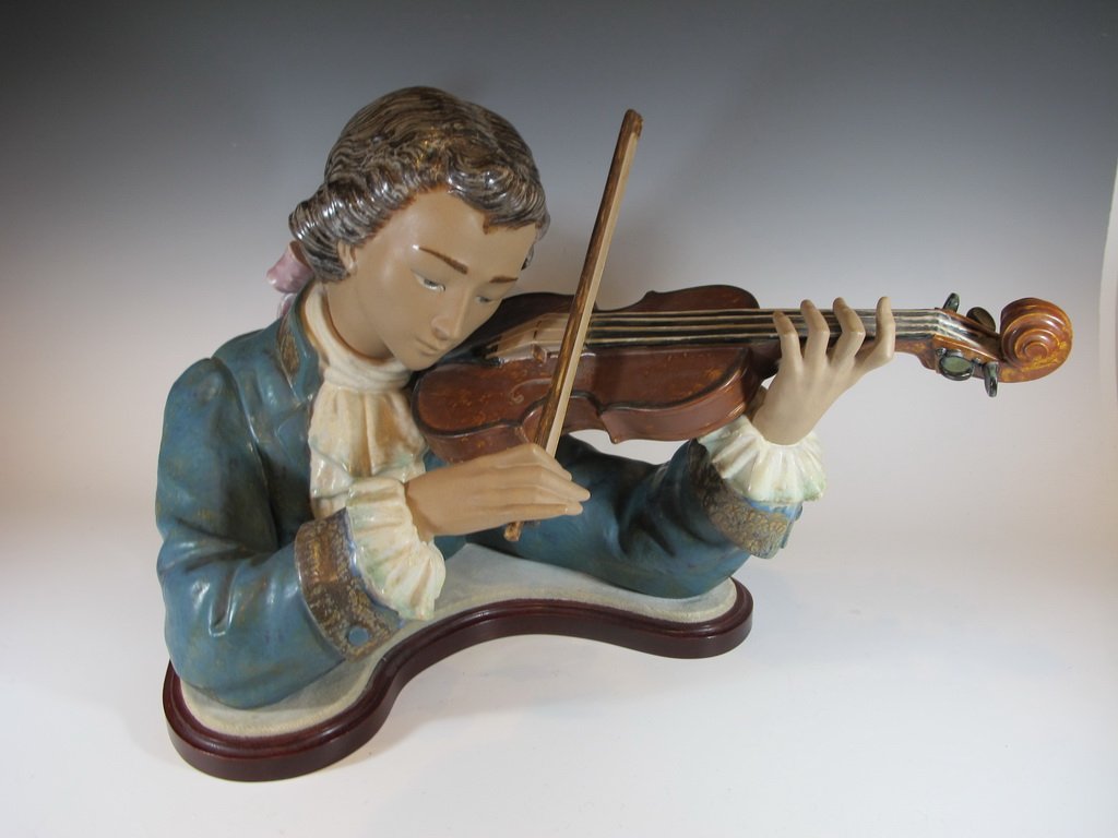 Lladro “Violin Player" porcelain sculpture: Lladro “Violin Player" porcelain sculpture on wooden stand, signed V. Martinez and J. Ruiz. Limited edition 275 / 1200, issued 1977, retired 1987. Sculptor Vicente Martinez. 13 5/8” H x 22” W x 