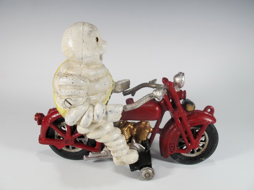 Cast iron figure of Michelin riding a bike: Cast iron figure of Michelin riding a bike. 6 5/8” H x 8 3/8” W. Shipping in USA is $ 30.00. International bidders ask for shipping before bid.
