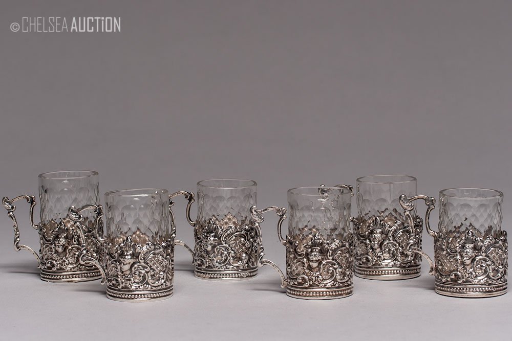 17th C German Silver Cup Holder & Glass Liquor Cups: German silver liquor cup holders with glass cups (set of six), 17th century. Hallmarked Lubeck cont’d, maker mark “B M”. A few cup holders have English Chester 1904 import marks. Silver mark 925