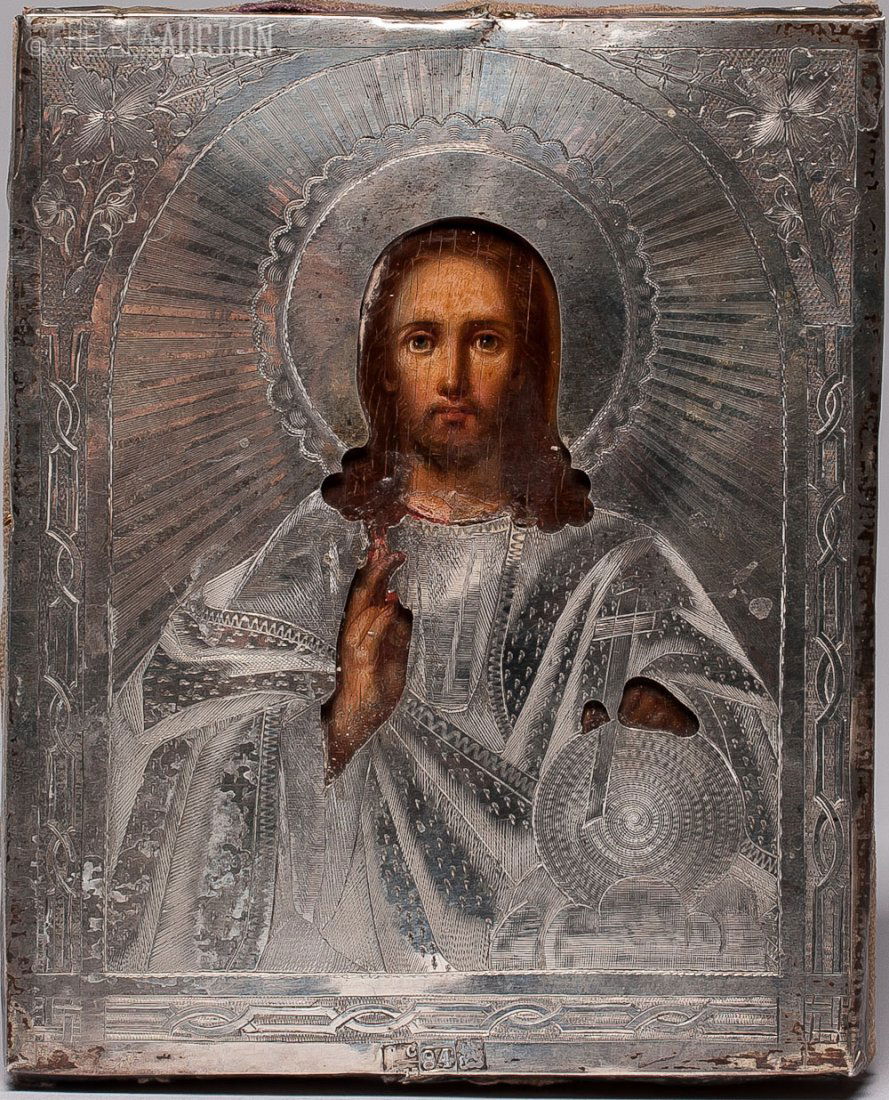 19th C. Russian icon: Jesus Christ w/ Silver Cover: 1873 Russian icon with silver cover. Egg tempera and gesso on wood panel. Two splits on the back. Silver cover Hallmark Moscow, Standard 84 (875/1000). SIZE: L 5 1/2 in and W 4 1/2 in (14cm x 11.5cm)