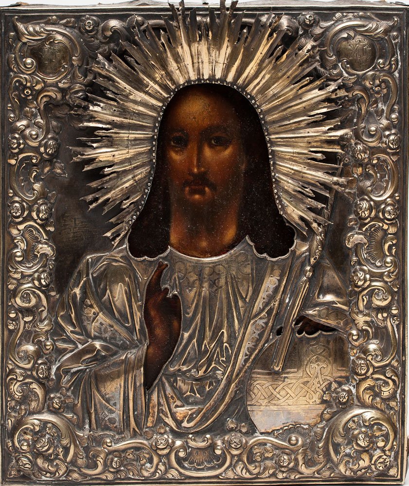 A RUSSIAN ICON OF CHRIST PANTOCRATOR, 19TH C.: A Russian icon of Christ Pantocrator, Central Russia, 19th century. Overlaid with silver-gilt repose and chased cover (oklad). Hallmarked Moscow, Imperial warrant and 84 standard (875/1000 silver), as