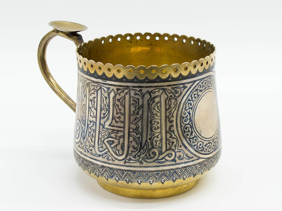 A RUSSIAN SILVER & NIELLO TEA GLASS HOLDER: A Russian silver-gilt and niello tea glass holder. Hallmarked 1878, Moscow, 84 standard (875/1000 silver), silversmith B.G. SIZE: Length 3 in (7.5 cm), weight 6.4 oz (181g).