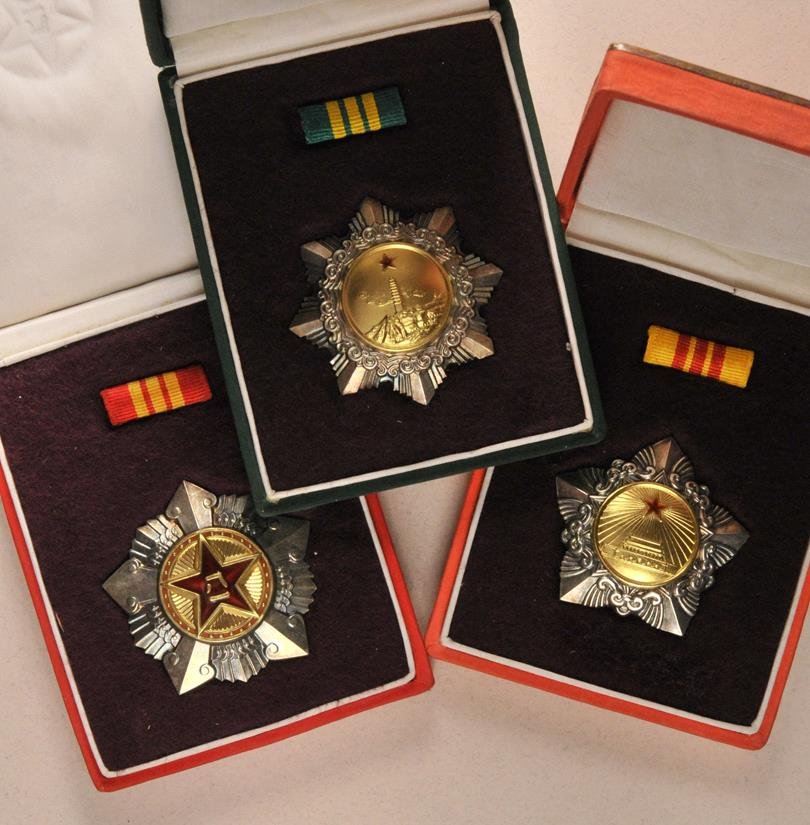 China - Lot of 3 decorations, in box.: China - Lot of 3 decorations, in box. All silver, partially gilded and enamelled, numbered, on pin, in gold embossed box of issue, ribbonbar inside. China - Lot von 3 Auszeichnungen, im Etui. Alle Sil