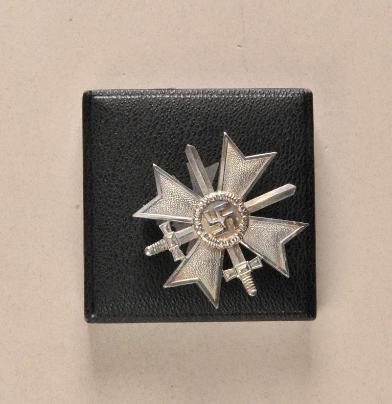 Germany (1933-1945) - War Merit Cross, 1. class with: Germany (1933-1945) - War Merit Cross, 1. class with swords, in box. Brass silvered, polished edges, pin hallmarked 1 (Deschler, München), in black half-box, silver embossed decoration on the top.#WC