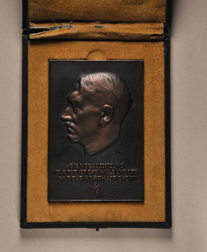 Germany (1933-1945) - Adolf Hitler Plaque, in box.: Germany (1933-1945) - Adolf Hitler Plaque, in box. Cast bronce, patinated, portrait over inscription "DIE VORAUSSETZUNG / ZUR TAT IST DER WILL UND DER / MUT ZUR WAHRHAFTIGKEIT, rreverse dedication "GE