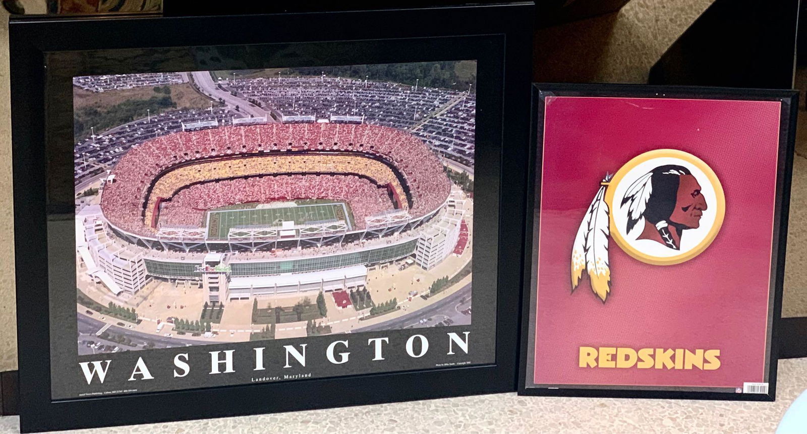 Two Framed Washington Redskins Posters: Two Framed Washington Redskins Posters. One Team Logo Framed Poster. Measurement Framed 16 1/4" x 20 1/4". One Stadium Poster That Reads WASHINGTON Landover, Maryland. Measurement Framed 31" x 25".&nb