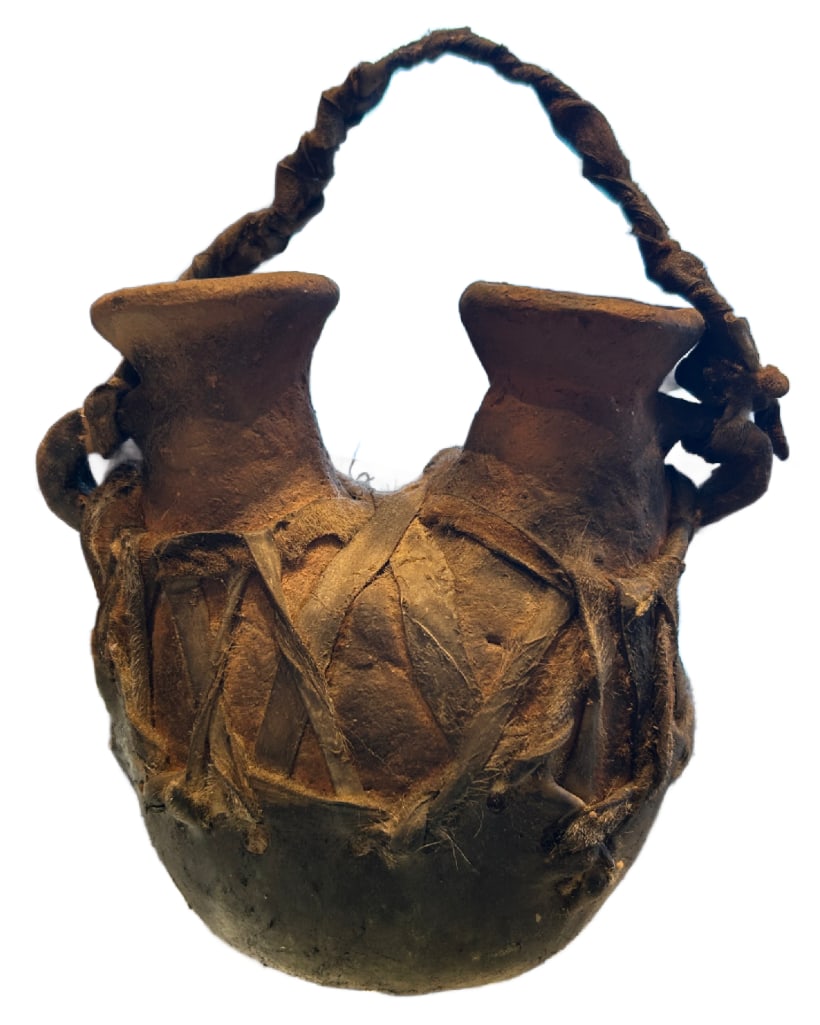 Vintage Double Spouted Pottery Vessel: Vintage Double Spouted Pottery Vessel. This lot includes one pottery vessel in good condition likely either Native American or African. It appears to be wrapped in some kind of animal skin which