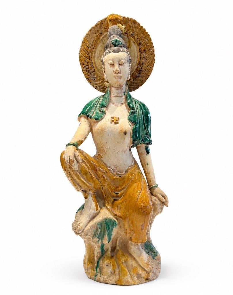 Buddhist Deity Guanyin in Royal Ease Pose: Buddhist Deity Guanyin in Royal Ease Pose. This lot includes one (1) statue depicting the Buddhist deity Guanyin seated in the Royal Ease pose. The figure is crafted from low-fired earthenware cl
