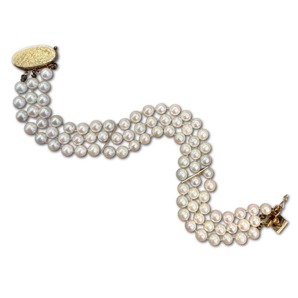 14k YG Ladies 3 Strand Pearl Bracelet: 14k Yellow Gold Ladies 3 Strand Pearl Bracelet Containing 5.5mm Saltwater Pearls Hand Knotted with Very Fine Lustre and Slight Cream Cast. The Bracelet is Approximately 7.5 inches in Length.