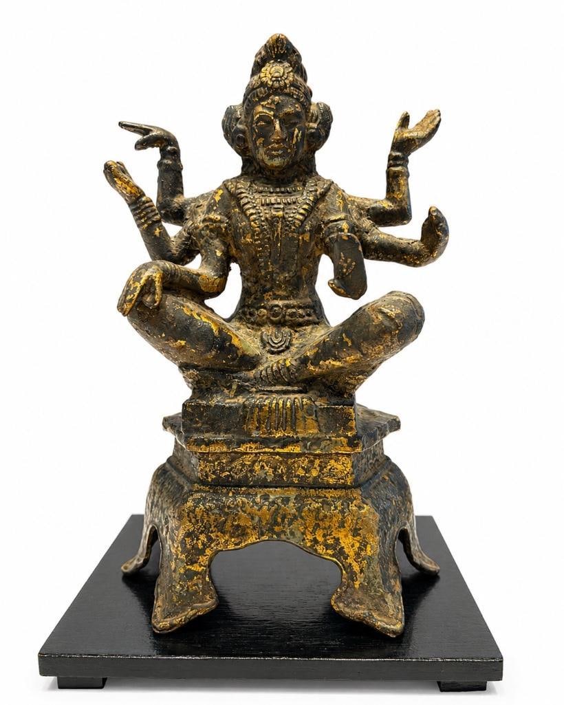 Asian Cast Iron Six Armed Vasudhara Buddhist Sculpture: Asian Cast Iron Six Armed Vasudhara Buddhist Sculpture. This lot includes one (1) vintage cast metal figure depicting a six-armed deity seated in a cross-legged pose atop an architectural-style
