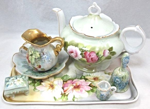 Collection of Hand Painted Porcelain: Collection of Hand Painted Porcelain to Include: Tea Pot Music Box, Small Creamer, Thumb Hole Dish, Bell, Miniature Creamer, Miniature Painted Box All on a Painted Tray Marked Prussia