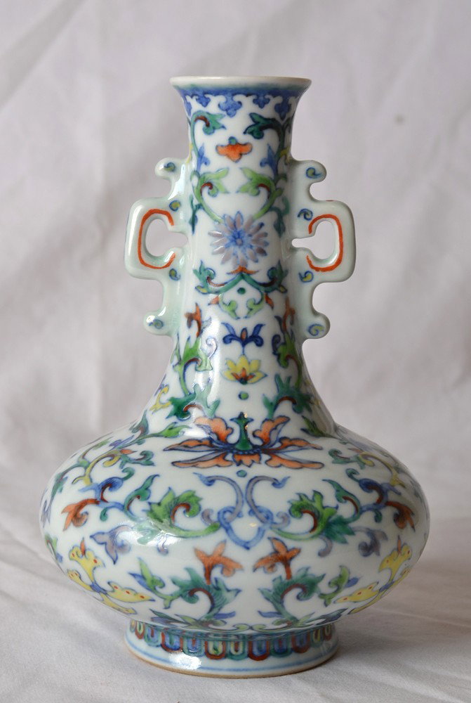 DOU CAI PORCELAIN VASE WITH HANDLES: Enameled depicting vines and flowers in multi-color, with two handles. Qianlong mark in blue. 6.25" H.