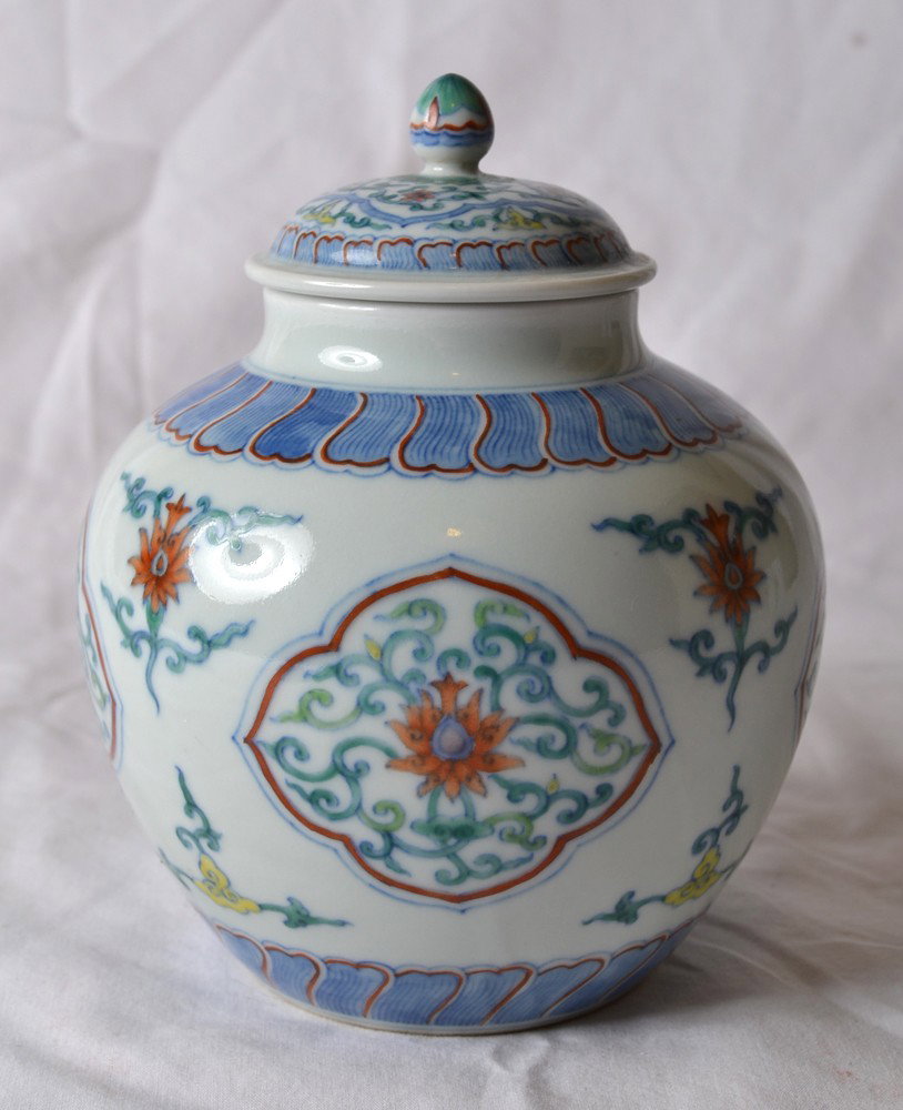 DOU CAI COVERED JAR: Enameled with flowers and cartouche shapes. Qianlong mark in blue. 6.25" H x 5" W.