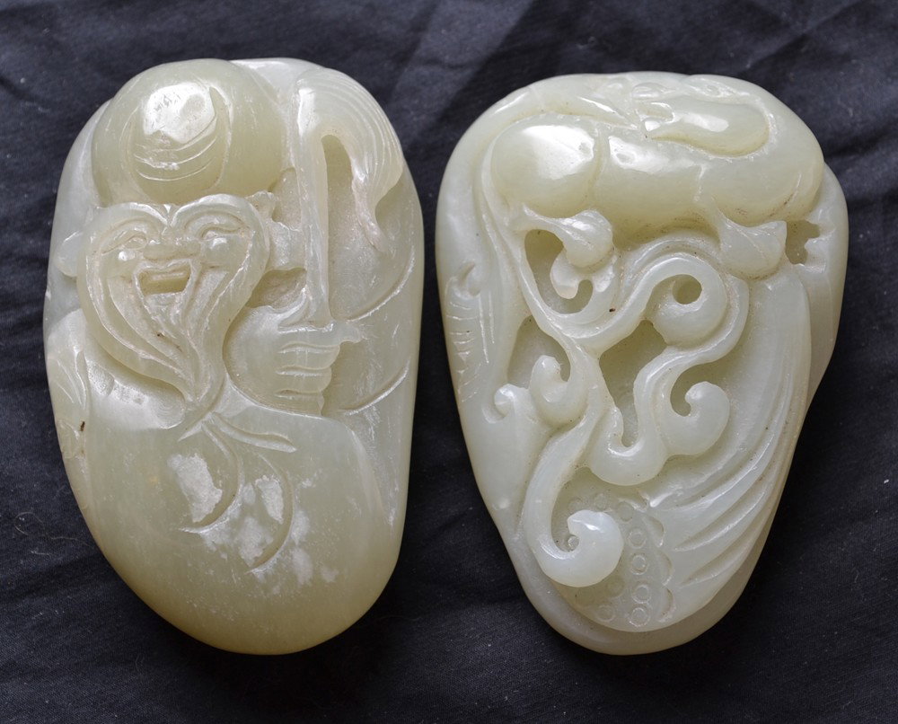 2 CARVED JADE BOULDERS: One carved with immortal and staff, the other carved with foo dog, vines and ruyi. Largest 3.25" L.