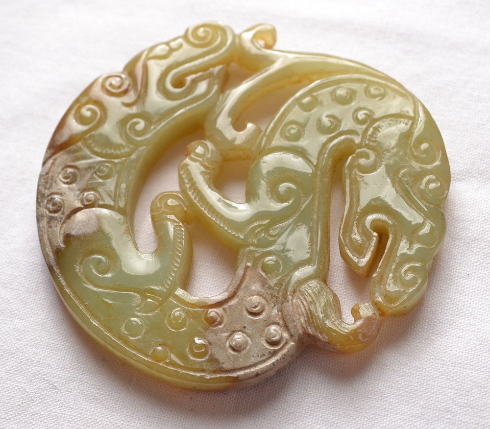CARVED JADE PLAQUE: Carved with 2 headed animal figure in a circle. 2" L.