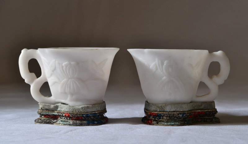PAIR OF ALABASTER TEA CUPS: With flower carvings, in box and with stands that match box. 1.625" H. Early 20th century.