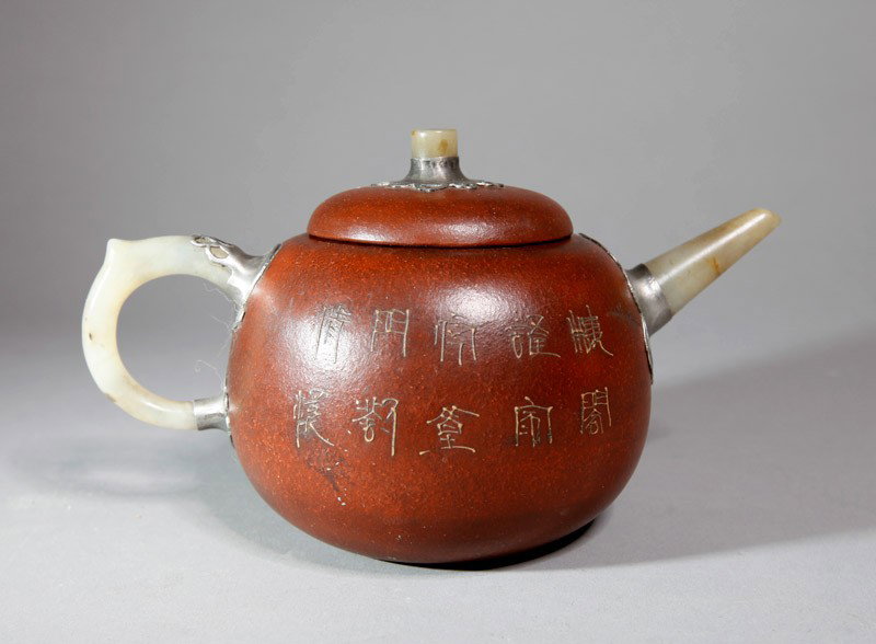 CHINESE ZI SHA TEA POT: With jade handle, spout and top of lid applied with tin, the body with raised and painted iris and butterflies to one side, and caligraphy to other side. Four character impressed mark. 4.125" H x 6.75