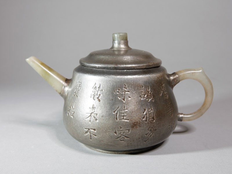 CHINESE TIN WRAPPED ZI SHA TEA POT: With jade handle, spout and top of lid, tin wrapped with caligraphy decoration. Four character impressed mark. 4" H x 6.5" L.