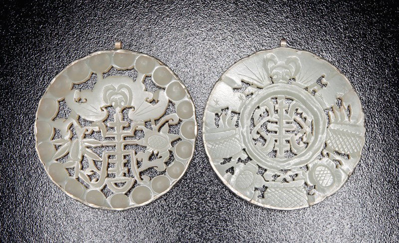 2 CHINESE MOUNTED JADE PLAQUES: One carved with Shou symbol and bats, the other carved with symbol, bat and flowers. Largest 2.25" DIA.