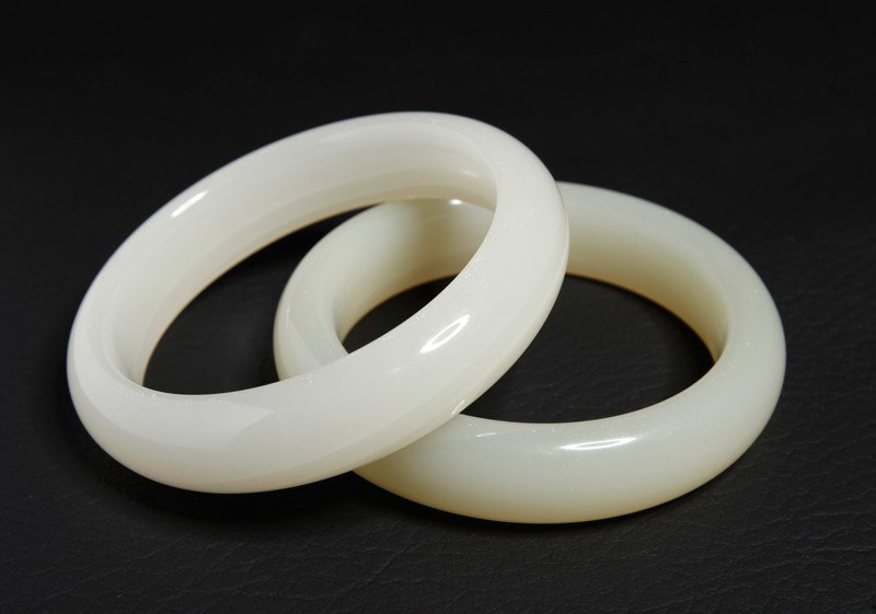 PAIR OF CHINESE WHITE JADE BANGLES: Smooth carved inside and outside. 2.5" inside diameter, 3.125" outside diameter.