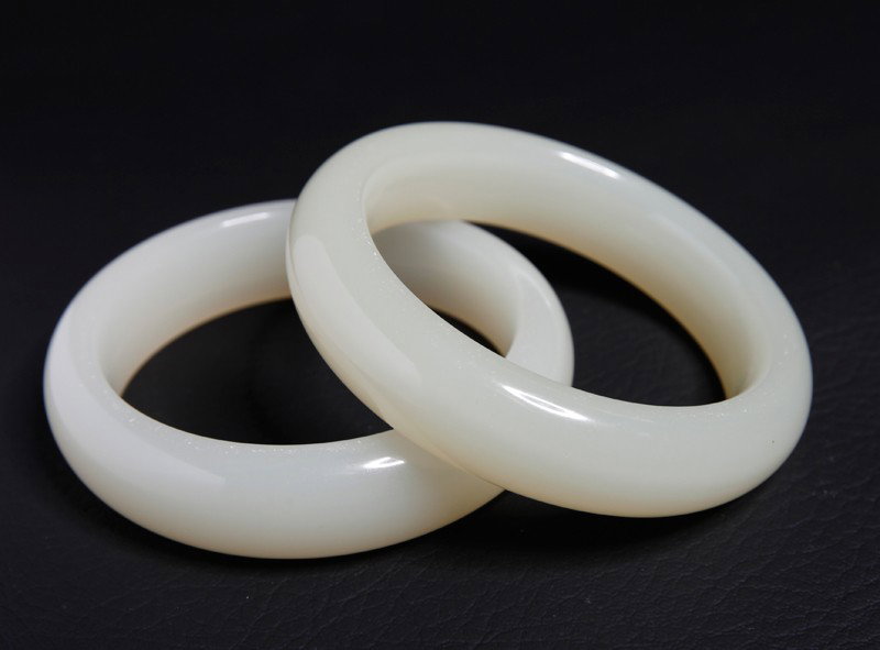 2 CHINESE CARVED WHITE JADE BANGLES: Both smooth carved inside and outside. 2.375" inside diameter, 3.25" outside diameter.