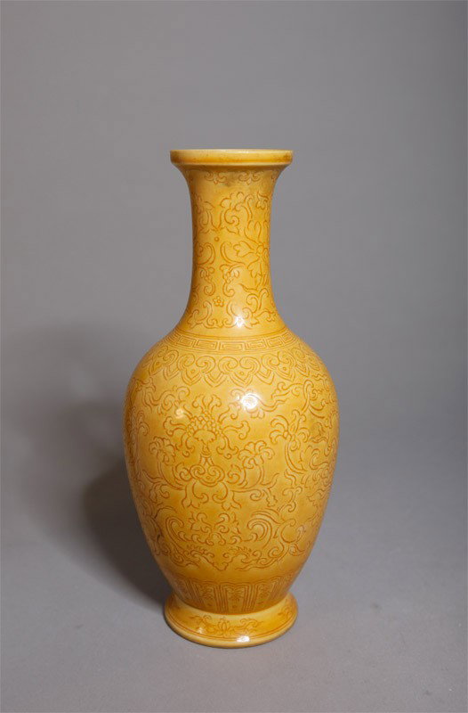 CHINESE PORCELAIN INCISED VASE: In saffron glaze with incised chrysanthemums and bats. Six character Qianlong mark in blue. 7.25" H.