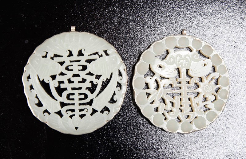 2 CHINESEMOUNTED JADE PLAQUES: Both carved with symbols and bats, mounted in silver. Largest 2.125" DIA.