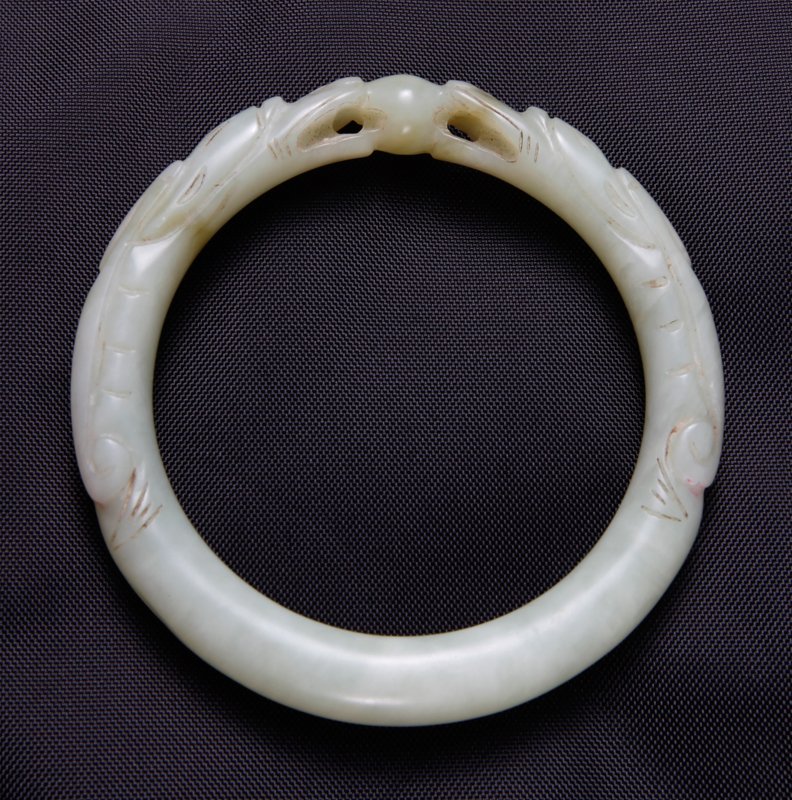 CHINESE QING WHITE JADE BANGLE BRACELET: Carved with two dragon mouths open with pearl in-between. 3.125" outside diameter, 2.375" inside diameter.