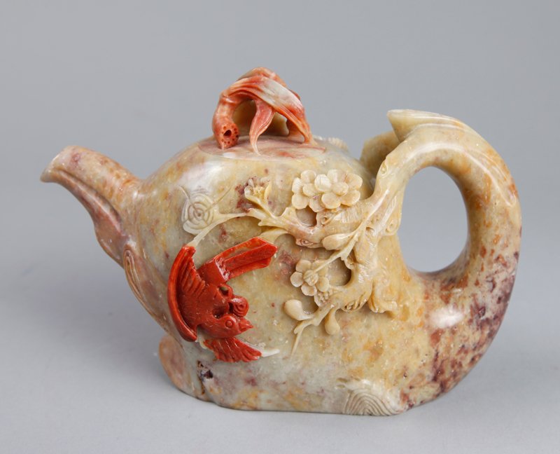 A VERY FINE CHINESE SOAPSTONE ELEPHANT TEA POT: Intricately carved in shape of an elephant with carved blossoms, lingzi and bird in red. The lid with bamboo and foliage carving. 4.125" H x 6" L. Excellent condition.