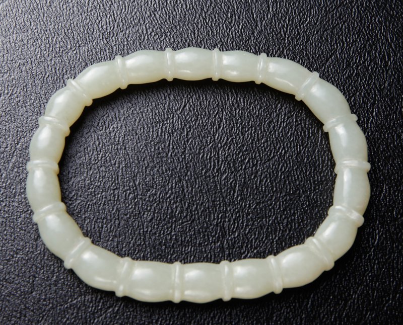 CHINESE CARVED JADE BANGLE: Oval in shape, carved with bamboo. 3.25" L x 2.5" W outside, 2.625" L x 1.75" inside. Excellent condition.