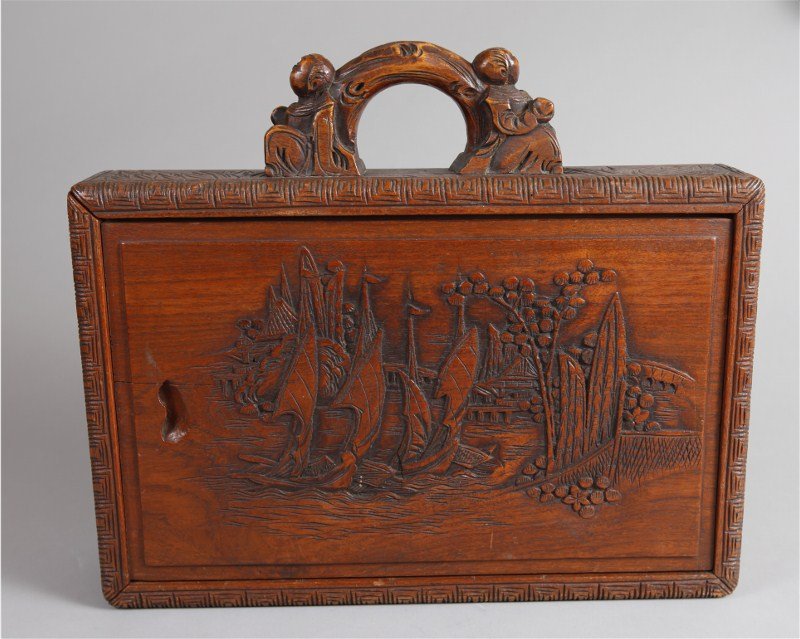 HAND CARVED CHINESE POKER BOX: Detailed carving of with both sides carved with sail ships in port, the handle carved with two boys, and the remainder carved with foliage. Inside contains chips, cards and dice. Box measures 12.75" h