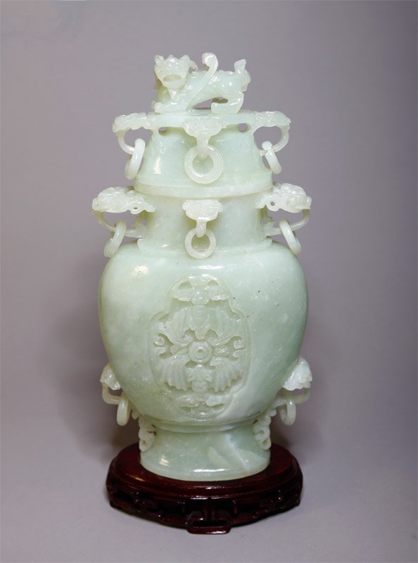 CHINESE SERPENTINE JADE COVERED URN: Carved urn with loose rings, bats and foo lion at top. 12" H, and 13.5" H with stand. Repair and small chip to one ring.