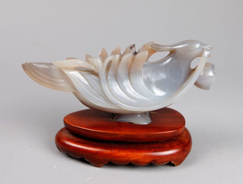 FINELY CARVED CHINESE AGATE DOVE & STAND: Beautifully carved with candlestick wings, holding a stemmed flower in its' mouth. Light gray stone with some russet and black inclusions. On a custom carved wood stand. 3.75" H x 5.875" L, with the s