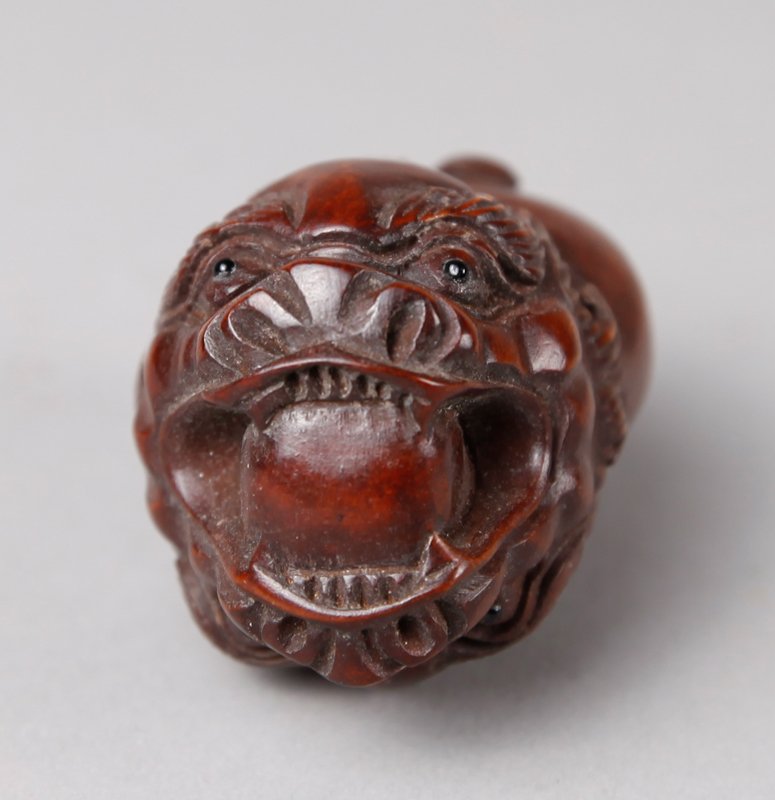 CHINESE CARVED BOXWOOD NETSUKE: Carved on both sides with two dragon heads and one mouth holding a pearl. 2.25" L. Excellent condition.