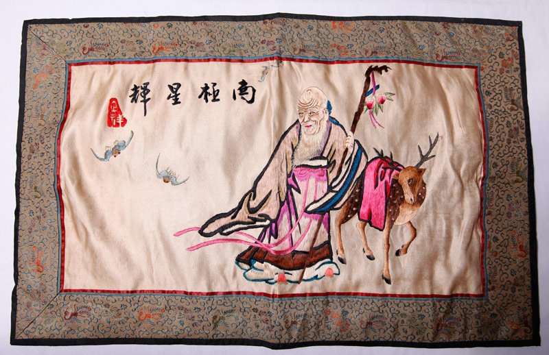 JAPANESE SILK EMBROIDERED PANEL: With a man, deer and bats, caligraphy and red seal mark. 12.25" H x 19.5" W. Very good condition.