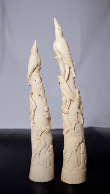 PAIR OF CHINESE CARVED IVORY TUSKS: Both carved with cranes, fish, monkeys and parrot. Tallest 11.25" H. Natural cracks to both, smaller one with loss at base.