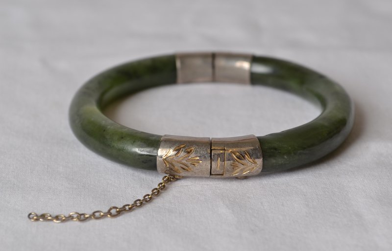 CHINESE JADE BANGLE: With metal clasps. 2.375" inside, 3" outside diameter. Excellent condition.